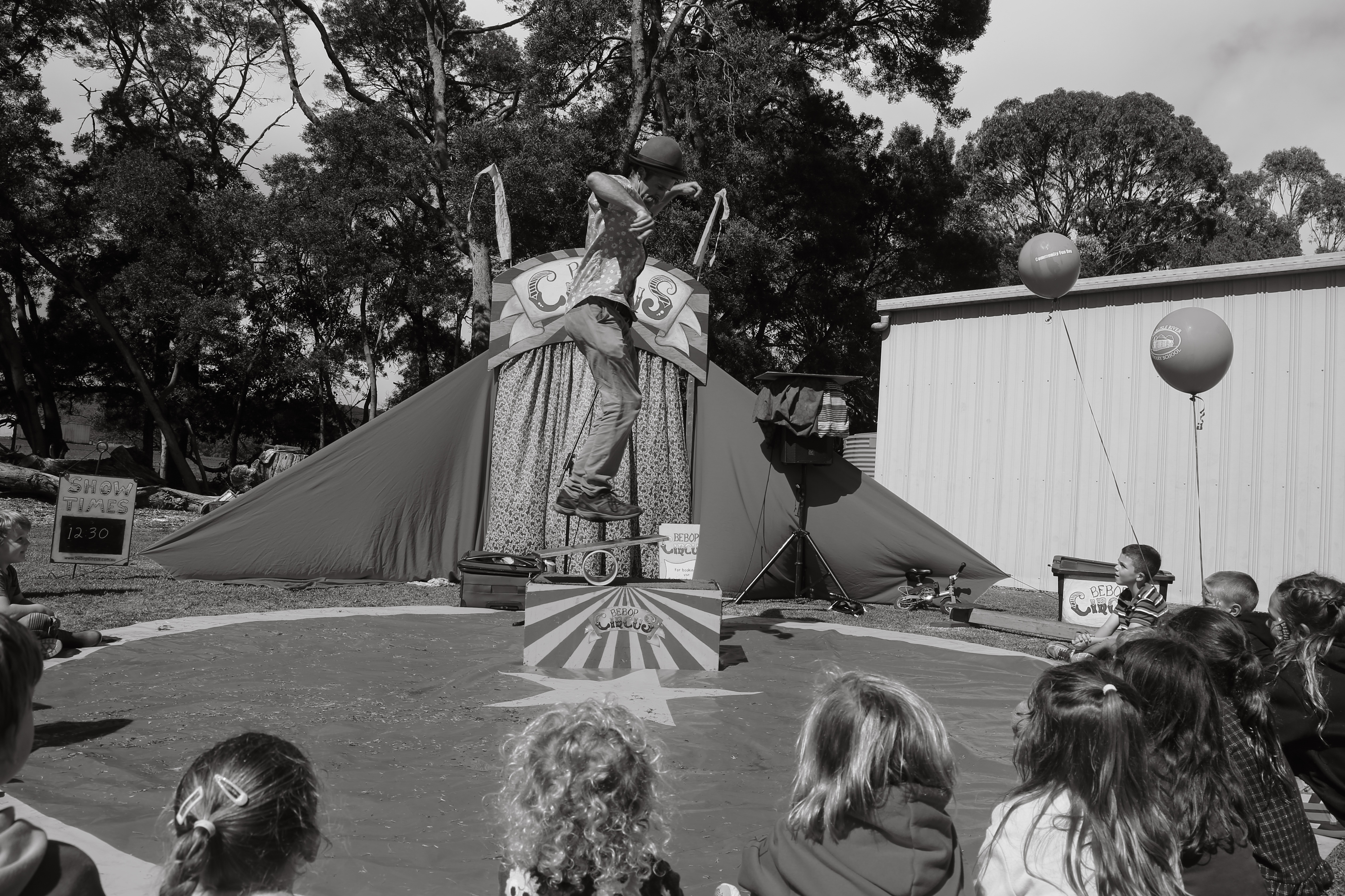 Black and white photograph of a circus performer at a community event