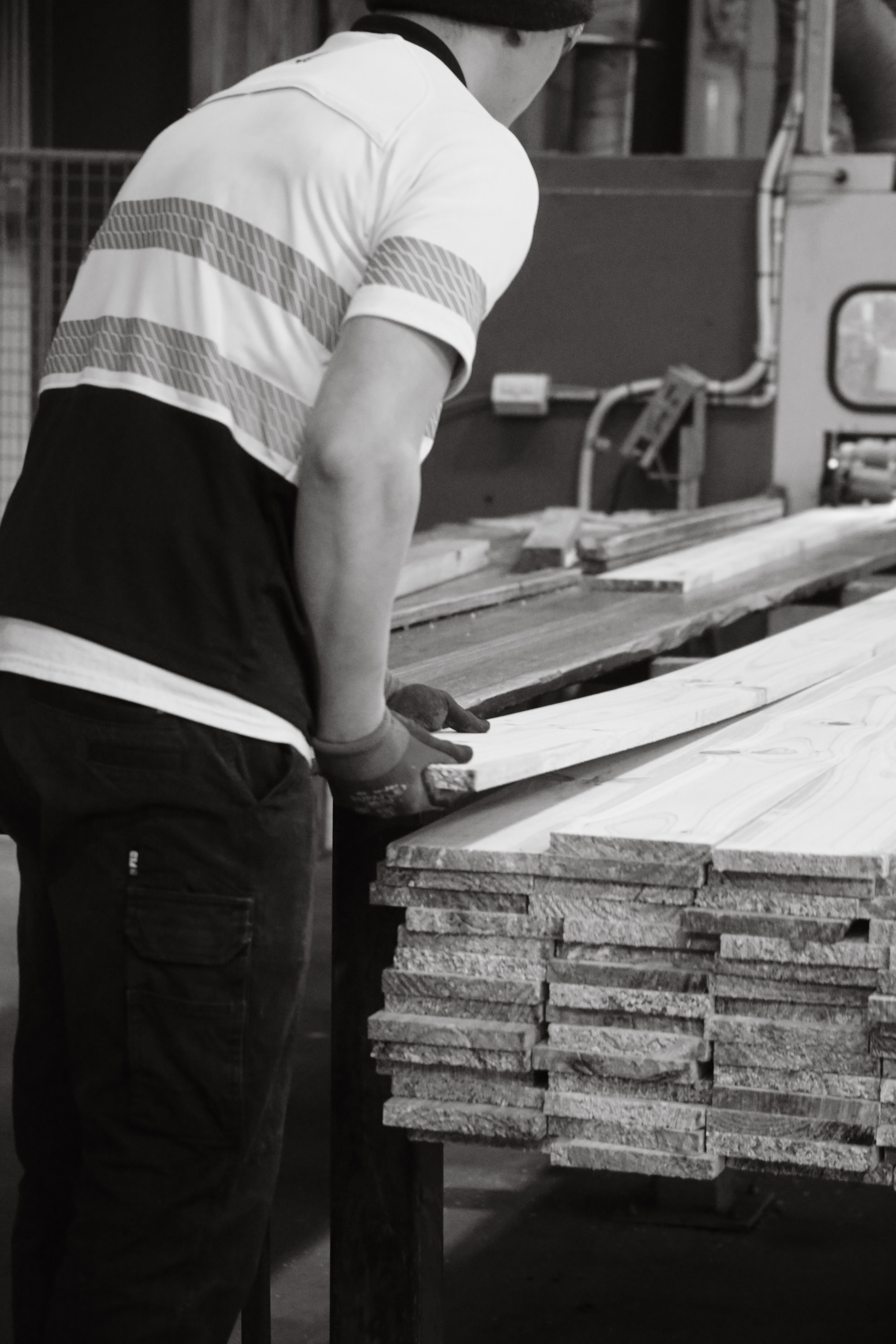 Worker handling timber boards, black and white portrait