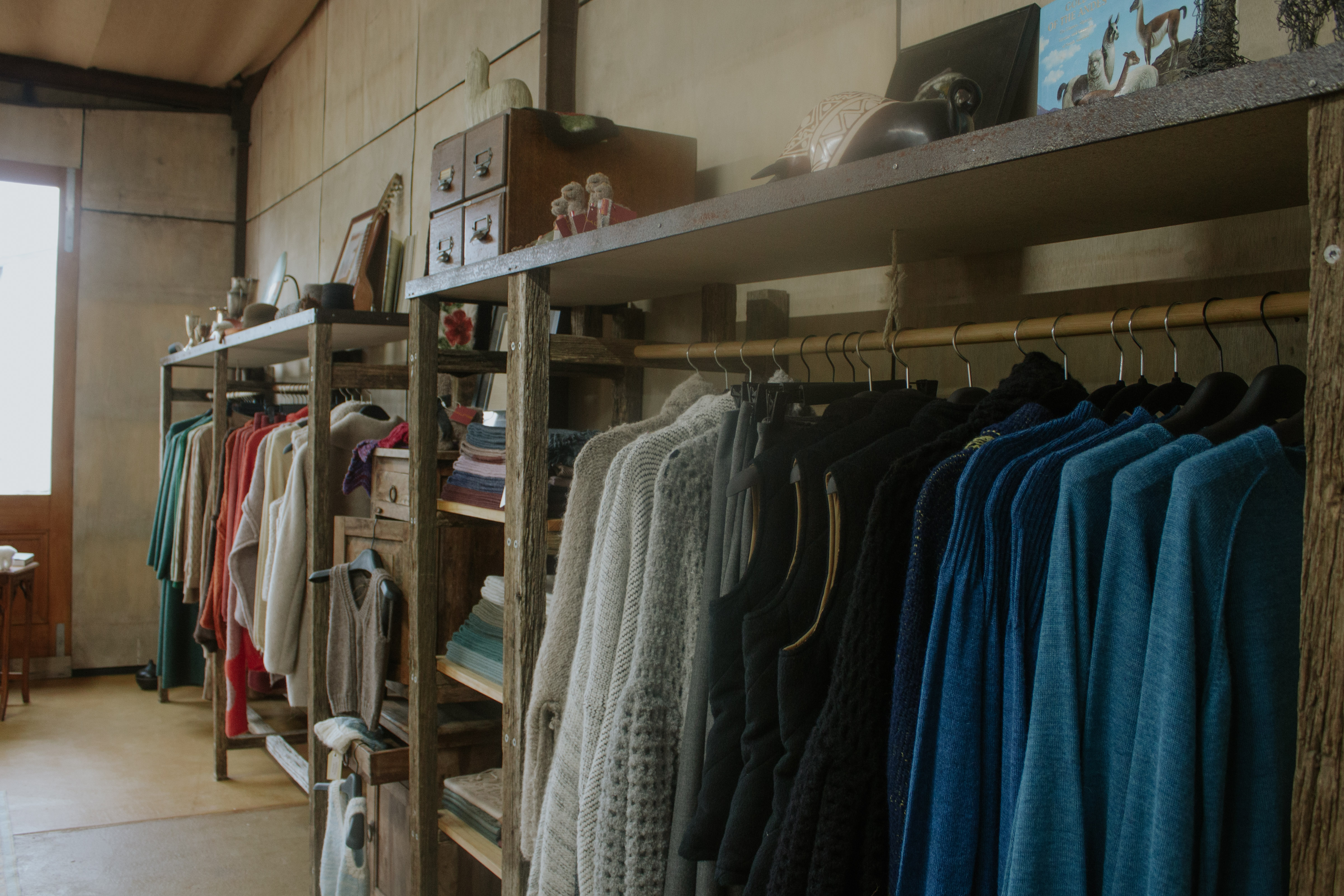 Clothing rack with teal, grey and red garments