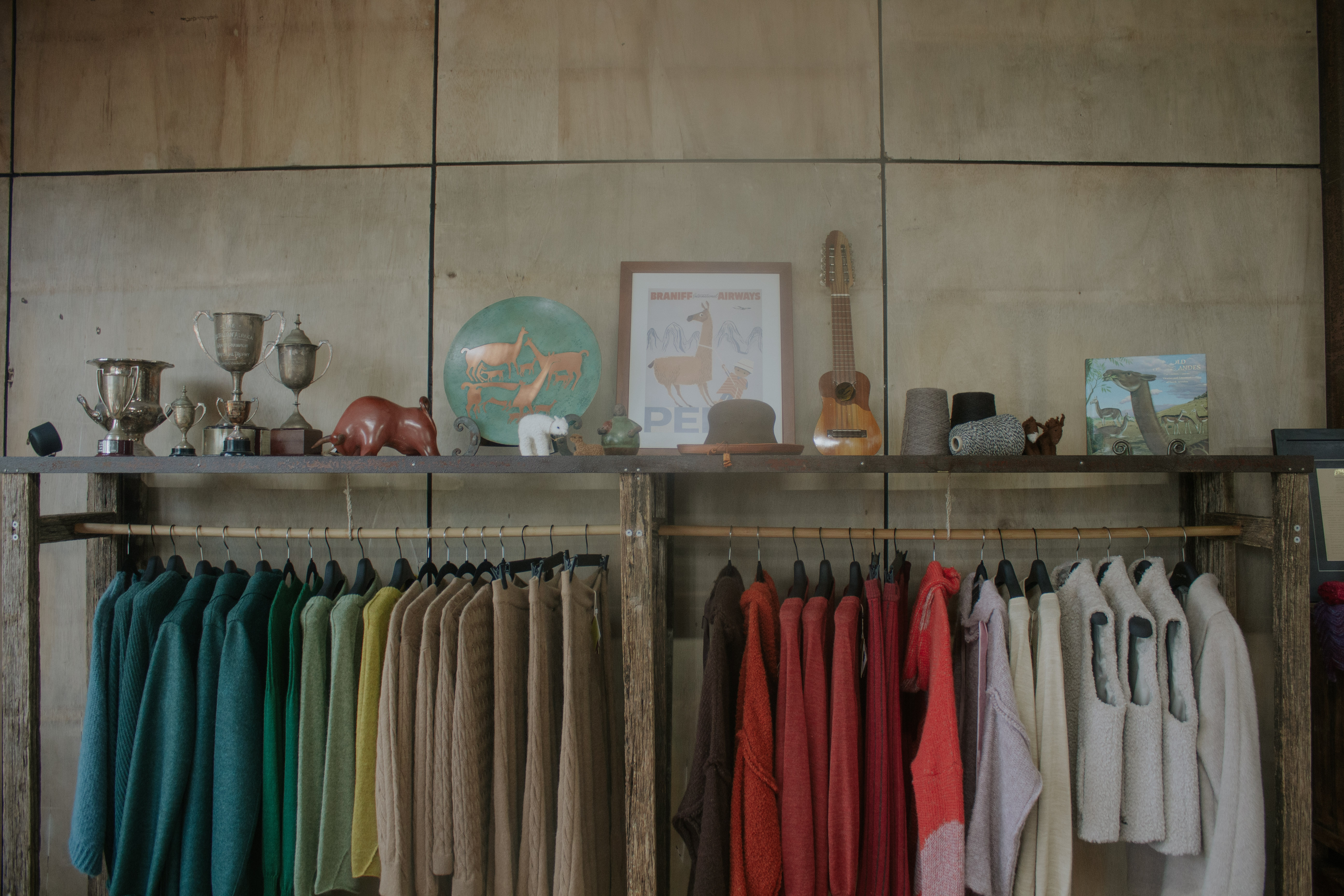 Colourful clothing rail with trophies displayed on the shelf above