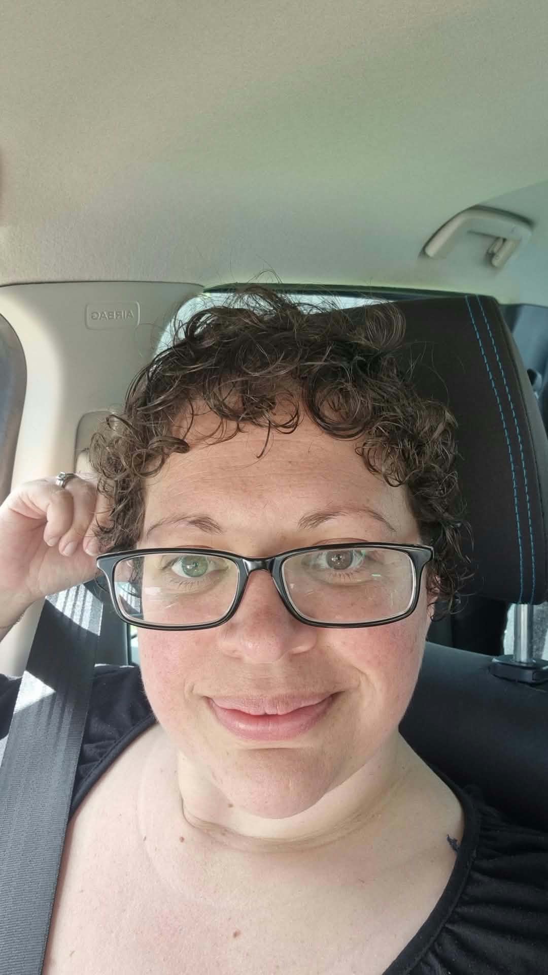 A close portrait of Ronnie in the car, looking directly into the camera with quiet resolve